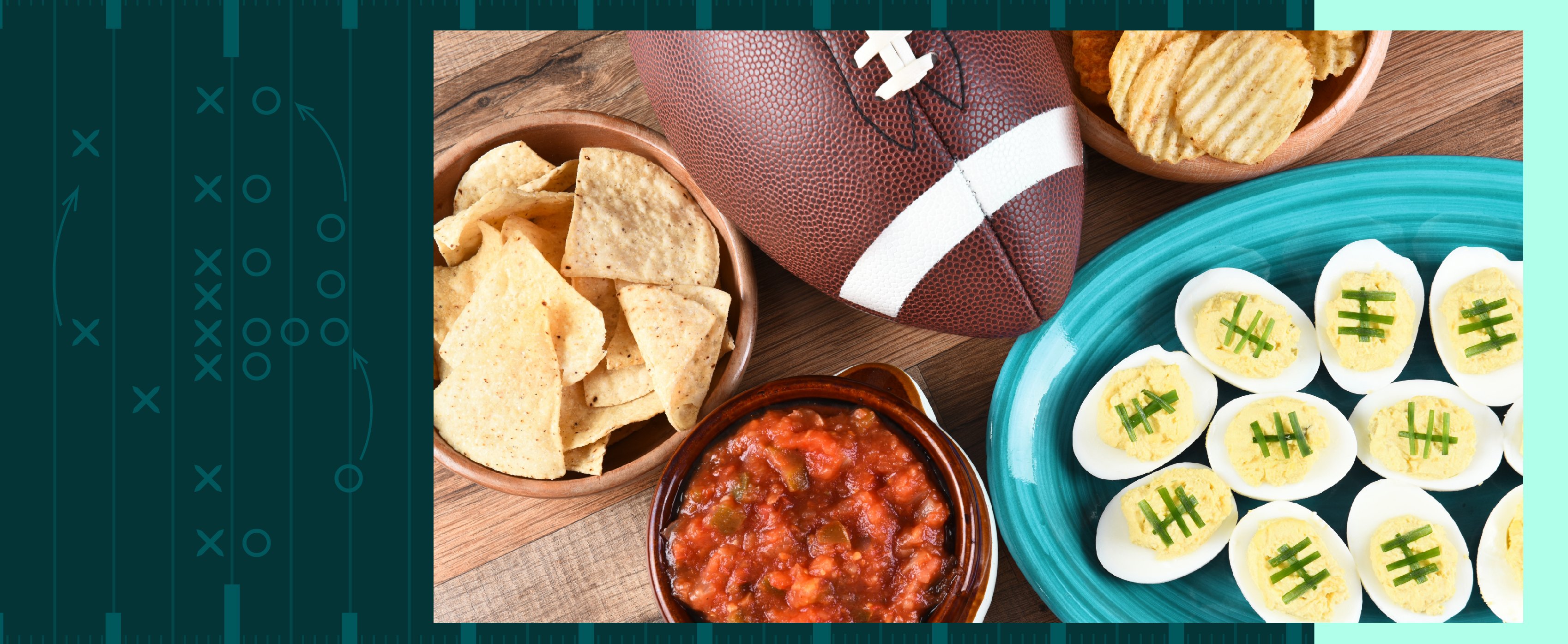 A table with a football, surrounded by tortilla and regular chips, salsa, and deviled eggs