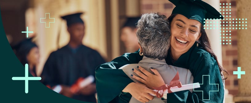 College graduate wearing a cap and gown hugging a family member.