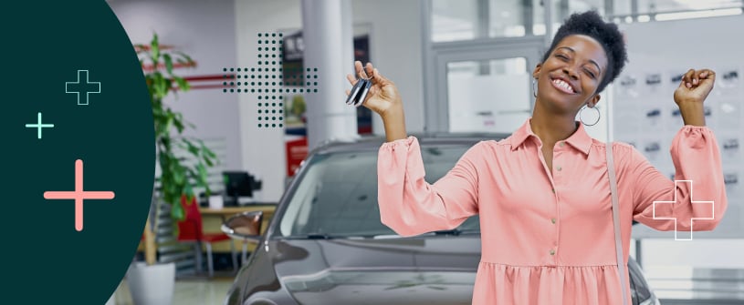 Woman holding her car keys in front of her new car. 
