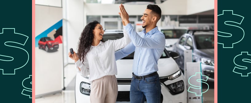 Two people high fiving each other in front of their new car
